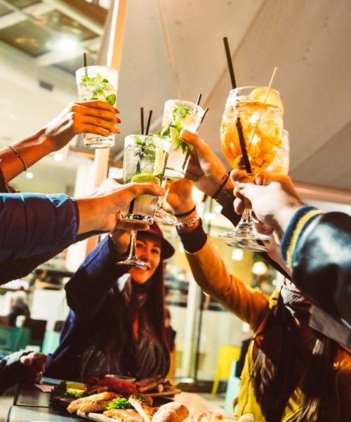 group-of-friends-wearing-protective-face-masks-drinking-cocktails-at-night-bar.jpg